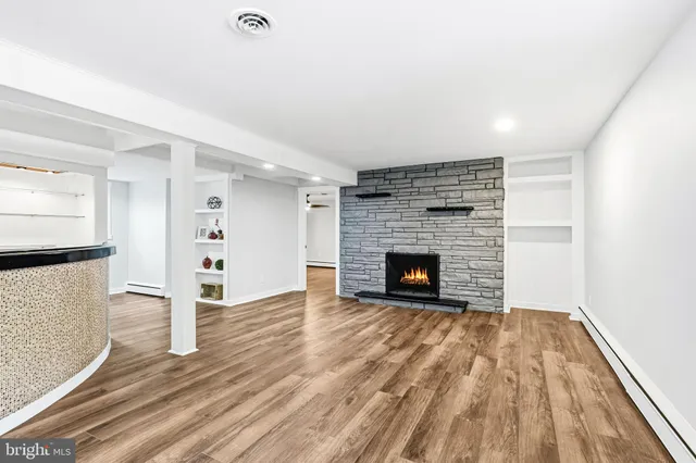 a view of empty room with wooden floor and fireplace