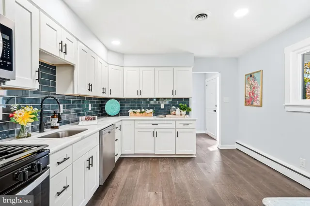 a kitchen with granite countertop white cabinets and white appliances
