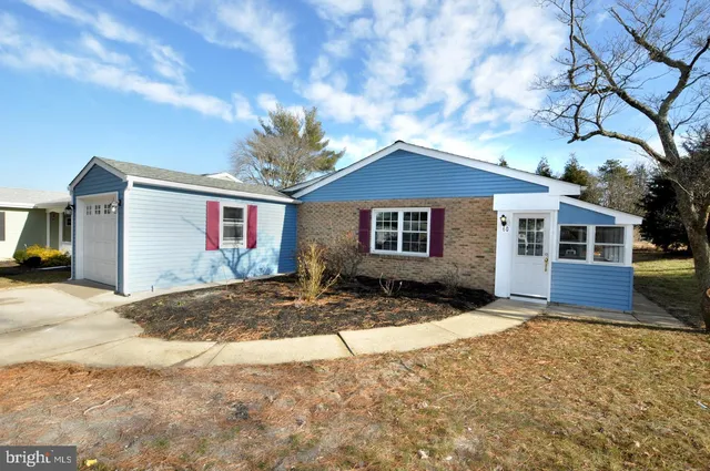 a front view of a house with a tree