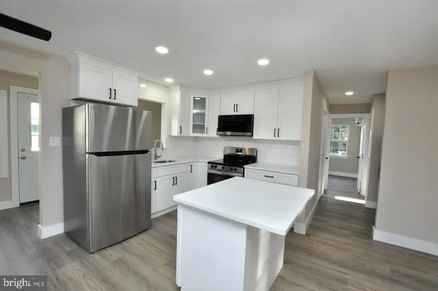 a view of a kitchen with refrigerator and window