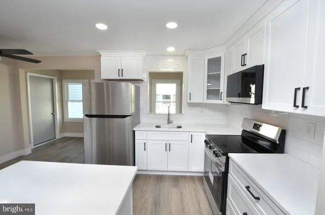 a kitchen with a refrigerator a sink and cabinets