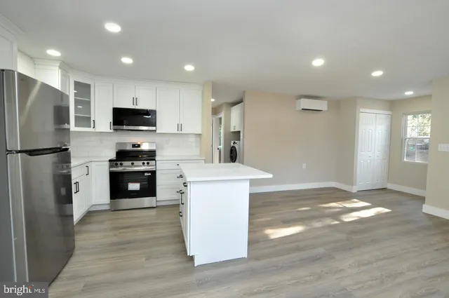 a kitchen with a refrigerator sink and wooden floor