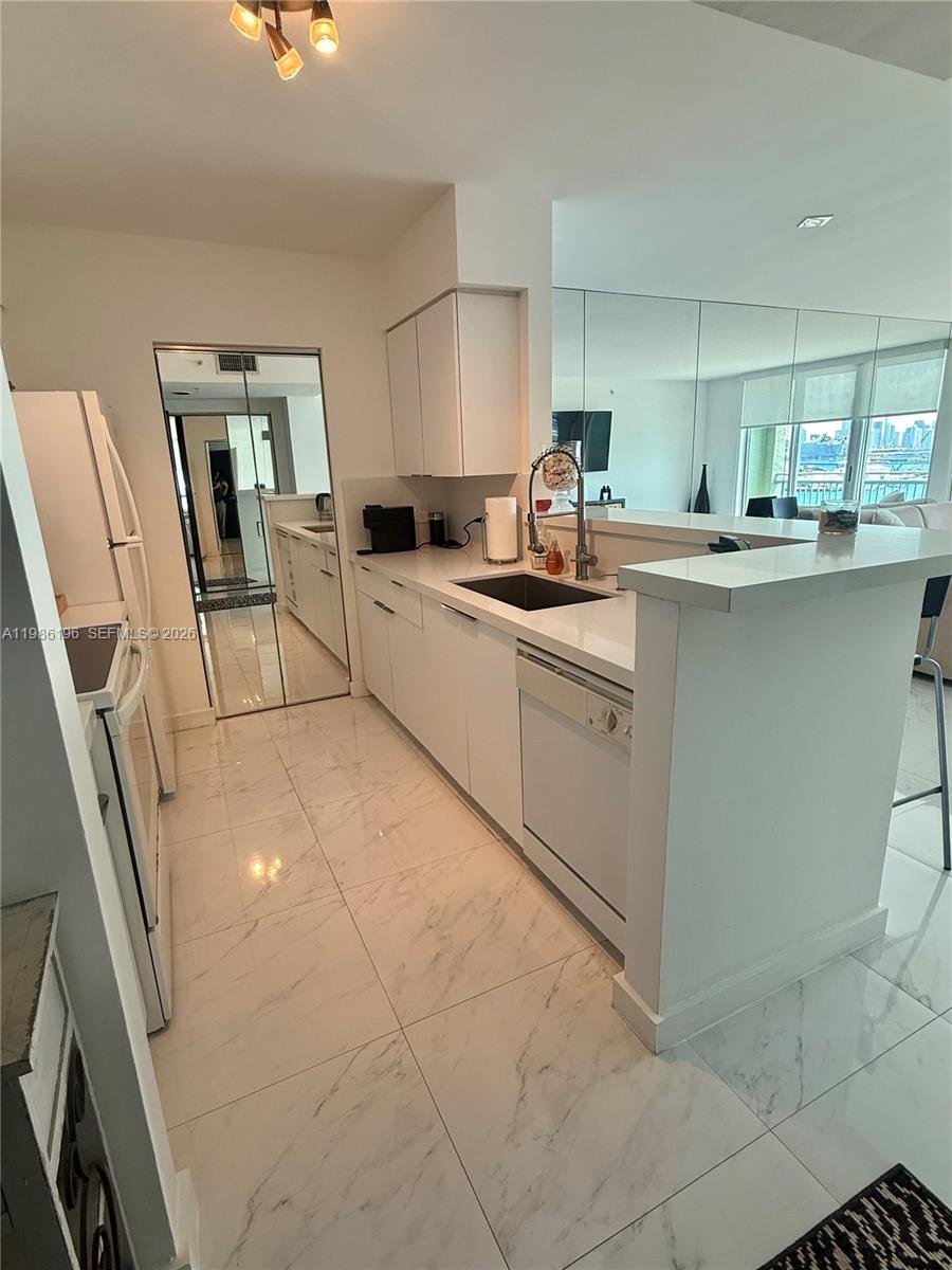 90 Alton Road, Unit 1106 Miami Beach, FL 33139 - Photo 5 of 21 a kitchen with cabinets and chair