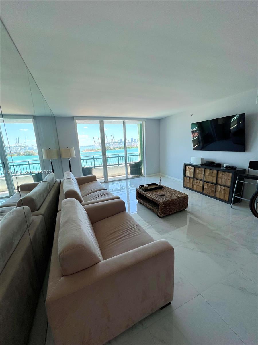 90 Alton Road, Unit 1106 Miami Beach, FL 33139 - Photo 6 of 21 a living room with furniture and a flat screen tv