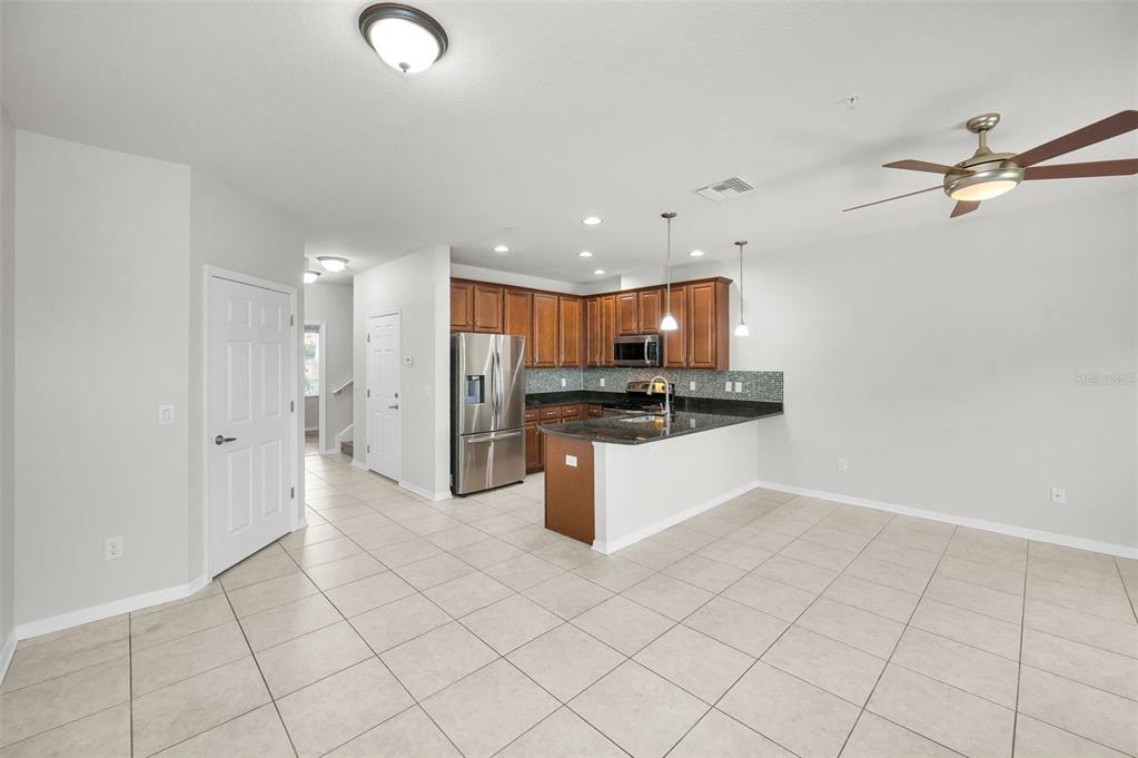 5032 Sand Castle Drive New Port Richey, FL 34652 - Photo 25 of 87 a kitchen with stainless steel appliances kitchen island granite countertop a refrigerator and a sink