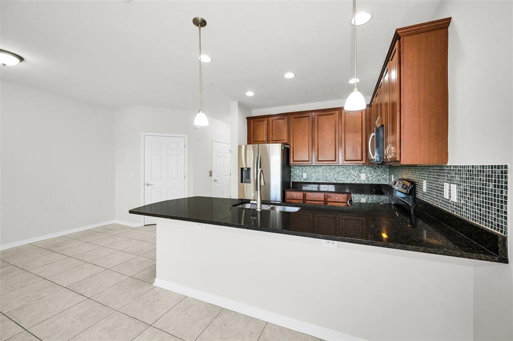 5032 Sand Castle Drive New Port Richey, FL 34652 - Photo 32 of 87 a kitchen with granite countertop a sink a stove and cabinets