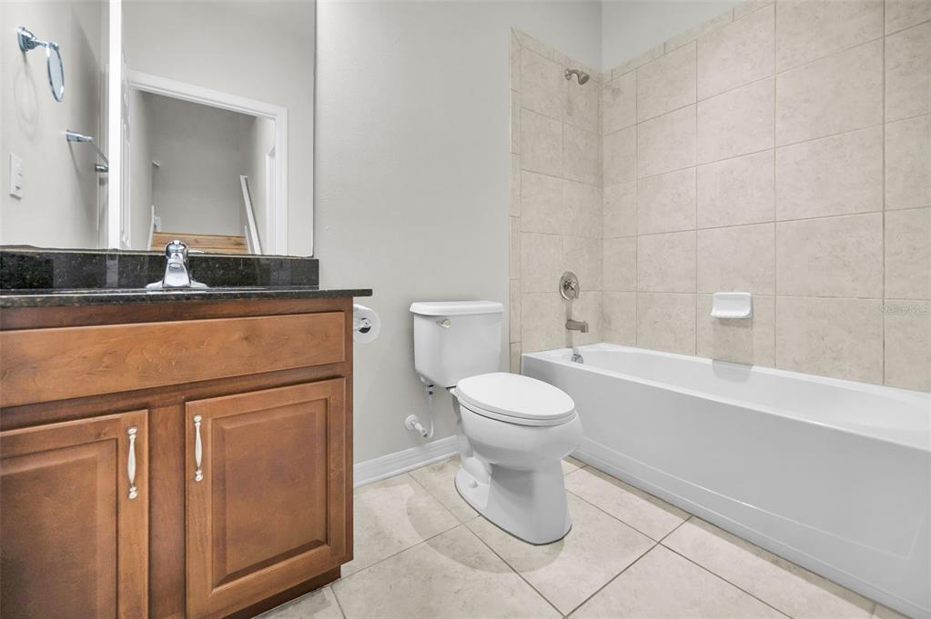 5032 Sand Castle Drive New Port Richey, FL 34652 - Photo 35 of 87 a bathroom with a toilet a sink a mirror and bathtub
