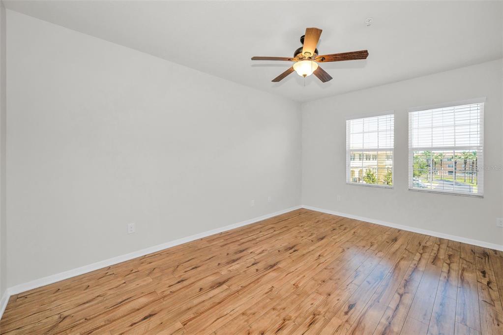 5032 Sand Castle Drive New Port Richey, FL 34652 - Photo 40 of 87 an empty room with wooden floor chandelier fan and windows