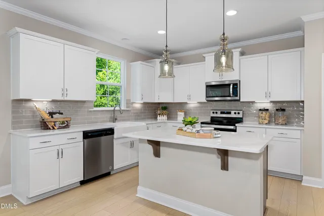 a kitchen with stainless steel appliances granite countertop a sink a stove a refrigerator cabinets and a window