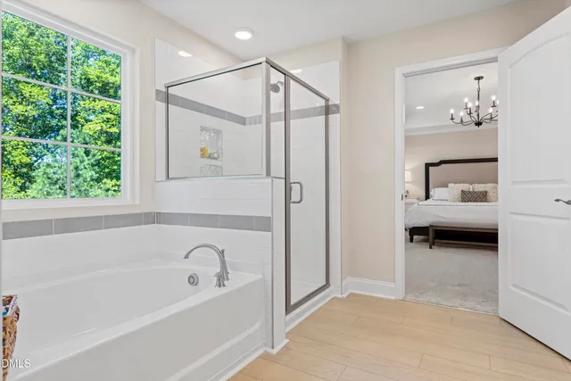 a bathroom with a tub a window and a shower