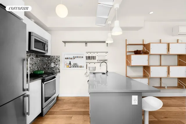 a kitchen with stainless steel appliances granite countertop a sink and a refrigerator