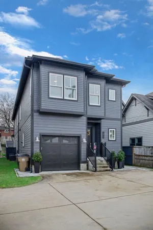 a front view of a house with a garden and garage