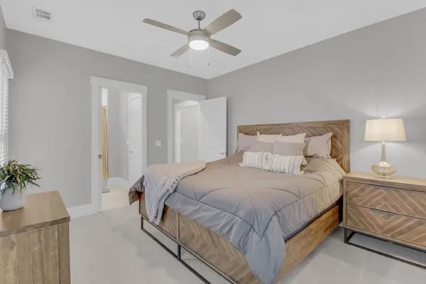 a bedroom with a large bed and a potted plant