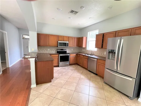 a kitchen with stainless steel appliances granite countertop a refrigerator stove a sink and microwave