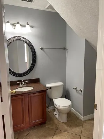 a bathroom with a toilet mirror vanity and a sink