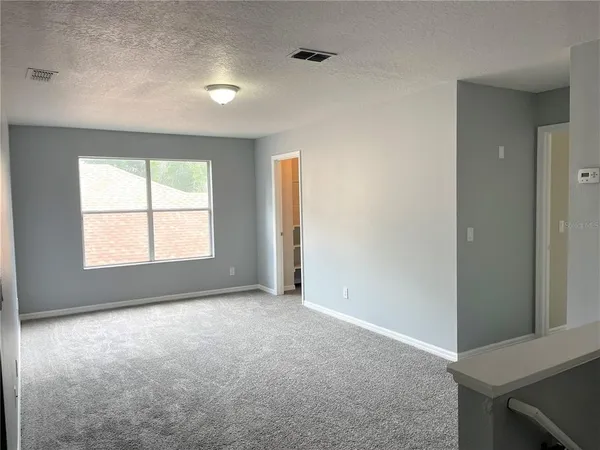 an empty room with windows and closet