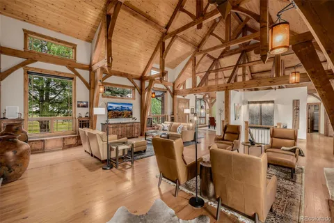 a living room with fireplace furniture and a large window