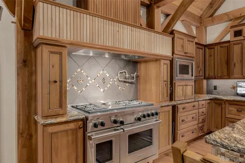 a kitchen with stainless steel appliances granite countertop a stove and a microwave