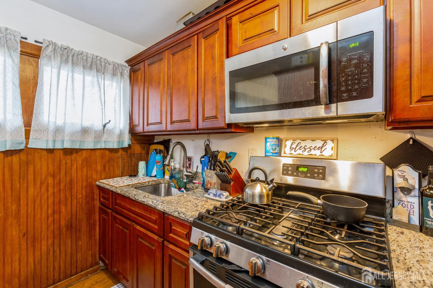 332 Ernston Road Parlin, NJ 08859 - Photo 12 of 14 a kitchen with stainless steel appliances granite countertop a stove top oven microwave and cabinets