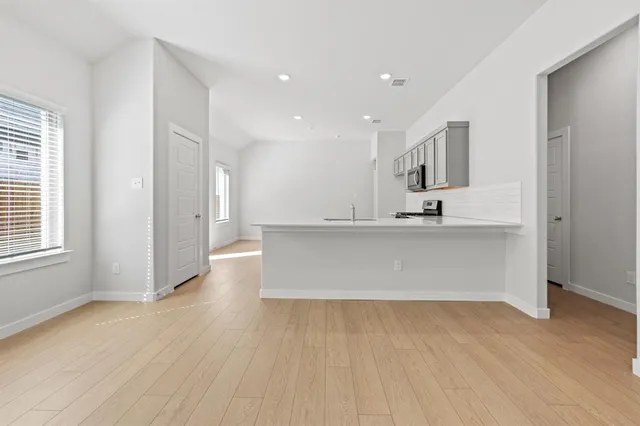 a view of kitchen with wooden floor and electronic appliances