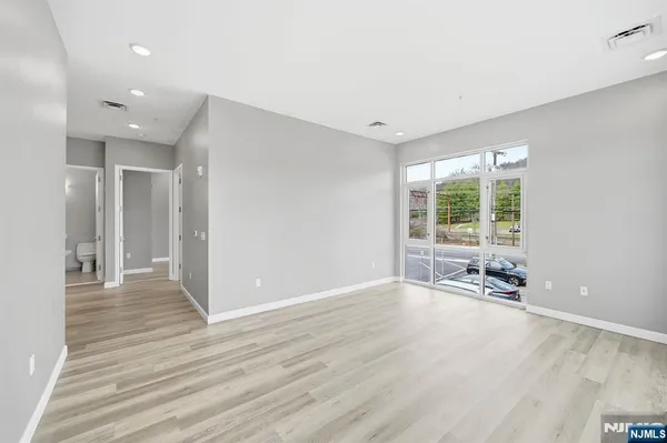 an empty room with wooden floor and windows