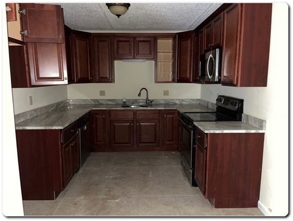 15 Lawrence Road, Unit 20 Rowley, MA 01969 - Photo 7 of 22 a kitchen with stainless steel appliances granite countertop a sink a stove and a refrigerator