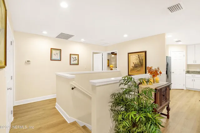 a view of a hallway with wooden floor and stairs