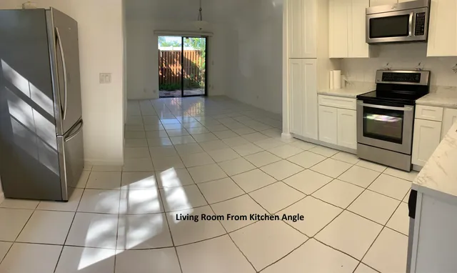 a kitchen with granite countertop a refrigerator and a stove top oven