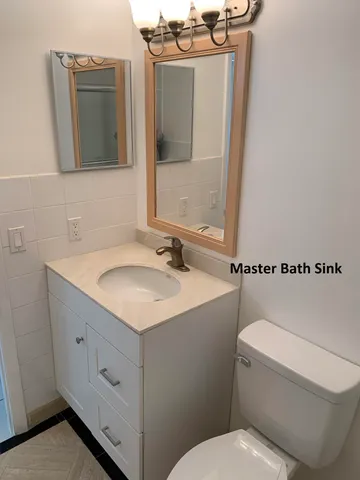 a bathroom with a sink a toilet and mirror
