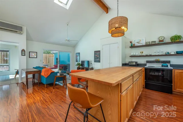 a kitchen with stainless steel appliances granite countertop a stove a sink dishwasher and white cabinets with wooden floor