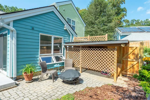 a side view of a house with a large window and potted plants
