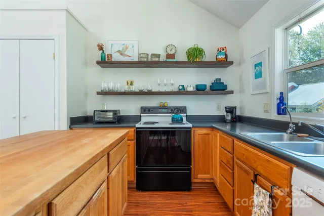 a kitchen with stainless steel appliances granite countertop a sink and wooden floors