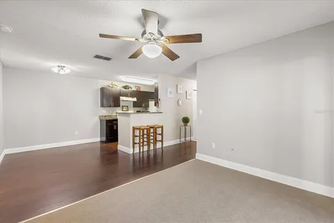 an empty room with windows and fan