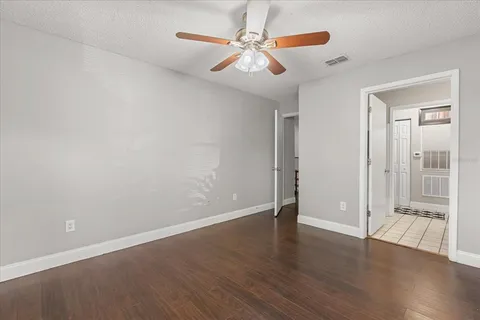 an empty room with wooden floor and window