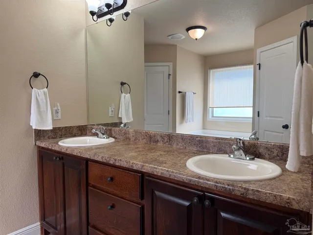 a bathroom with a granite countertop sink a mirror and shower