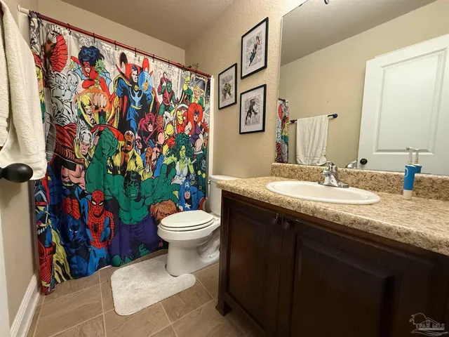 a bathroom with a granite countertop sink mirror vanity and toilet