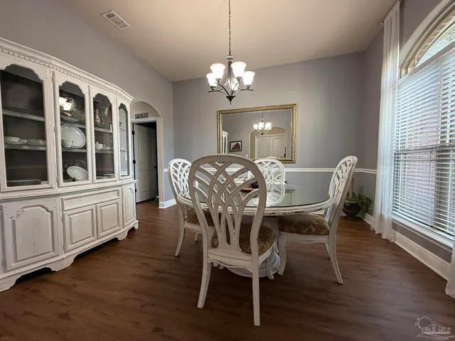 a view of a dining room with furniture wooden floor and chandelier