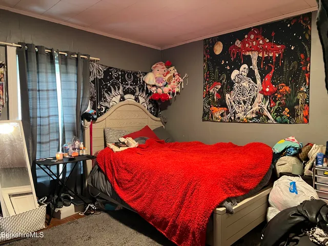 a bedroom with a bed and a painting on the wall