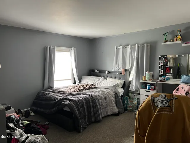 a bedroom with a bed a closet and a window