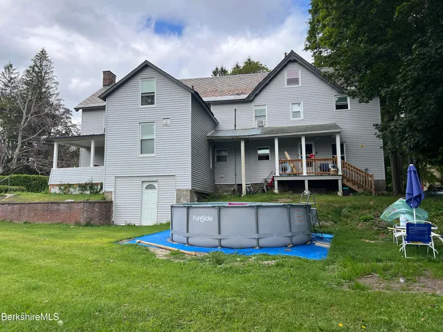 a view of a house with a yard and sitting area