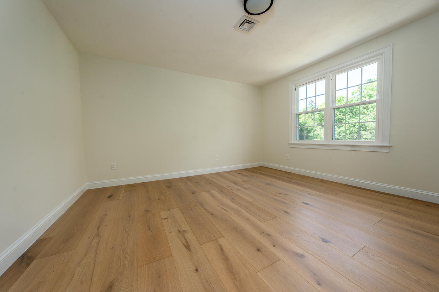 83 Whitmar Road Barnstable, MA 02635 - Photo 16 of 27 an empty room with wooden floor and windows