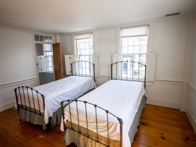 a bedroom with a bed next to a window