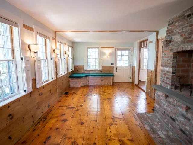 a view of an entryway with wooden floor and a fireplace