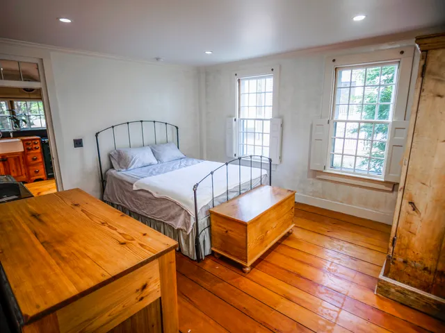 a bedroom with 2 bed and a window