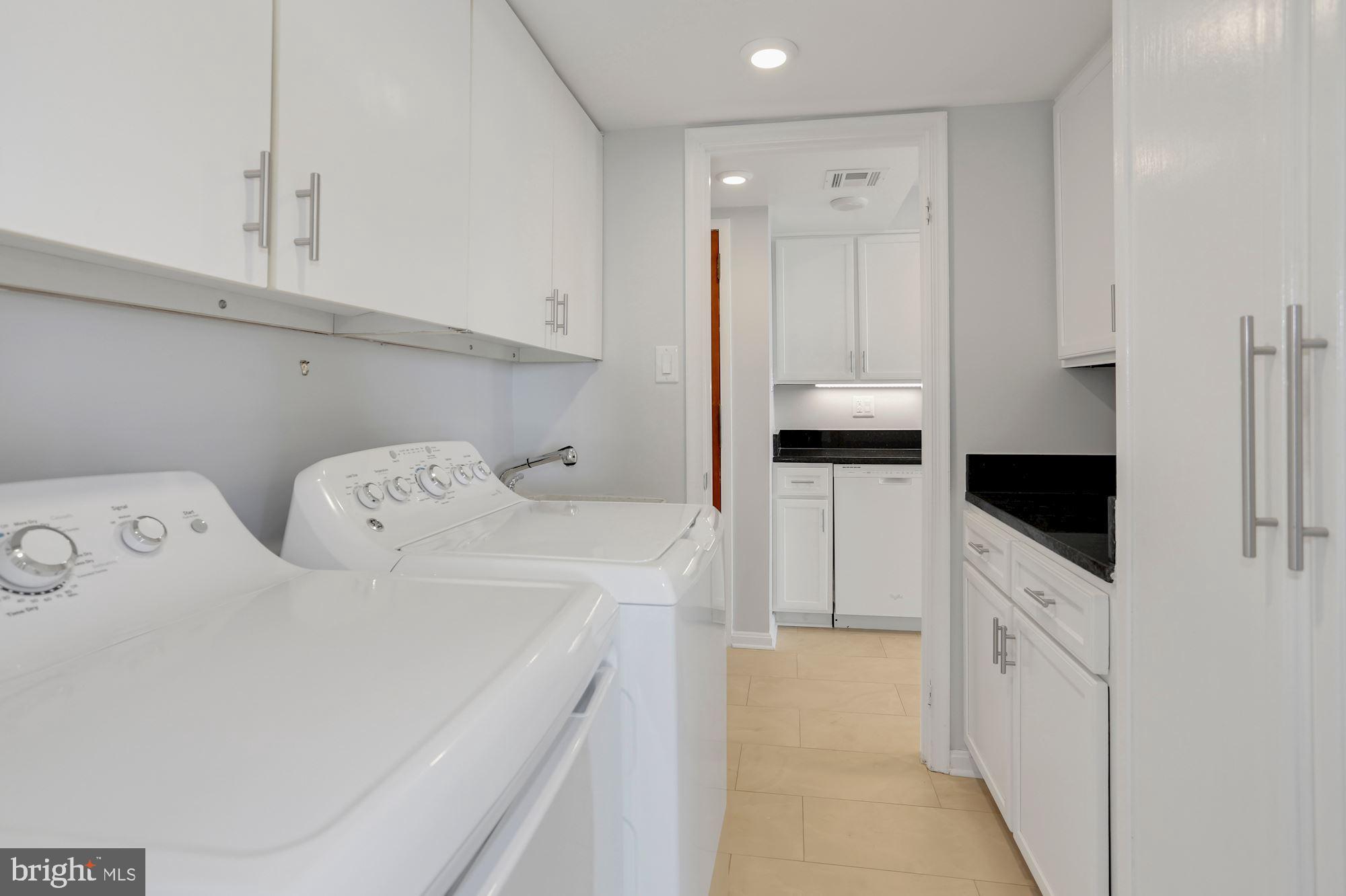 1101 South Arlington Ridge Road, Unit 902 Arlington, VA 22202 - Photo 11 of 38 a kitchen with white cabinets and white appliances