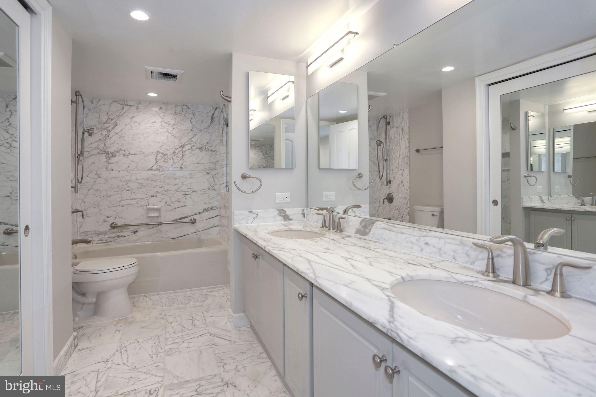 1101 South Arlington Ridge Road, Unit 902 Arlington, VA 22202 - Photo 23 of 38 a bathroom with a granite countertop sink a mirror a toilet and bathtub