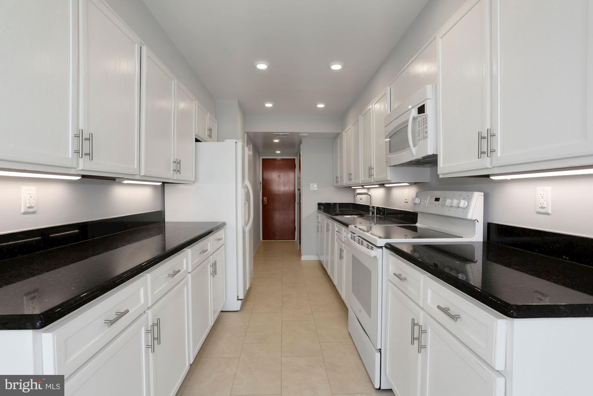 1101 South Arlington Ridge Road, Unit 902 Arlington, VA 22202 - Photo 8 of 38 a kitchen with granite countertop white cabinets and stainless steel appliances