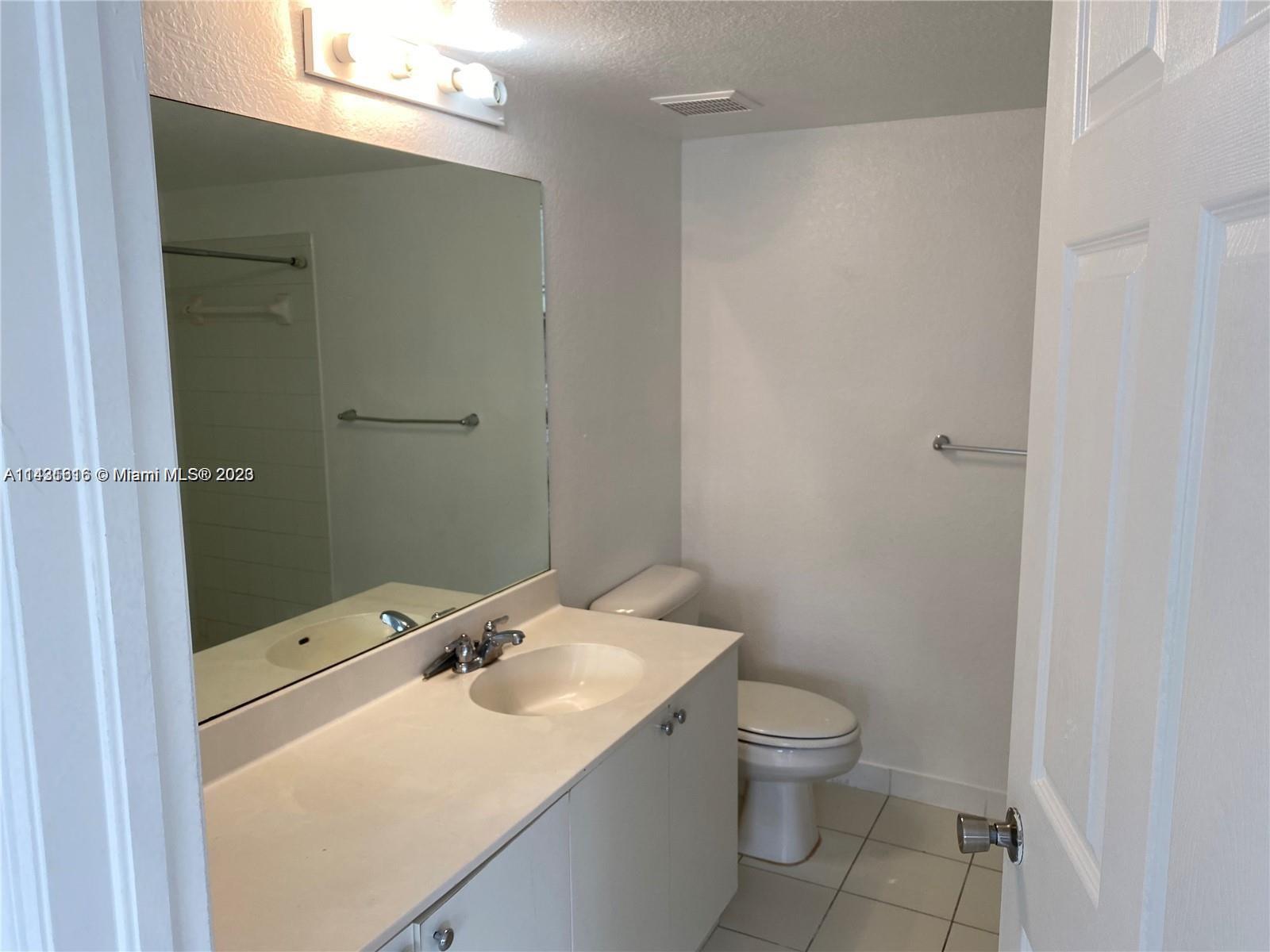 15440 Southwest 284th Street, Unit 5307 Homestead, FL 33033 - Photo 2 of 7 a bathroom with a sink a toilet and shower