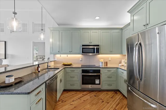 a kitchen with stainless steel appliances granite countertop a sink stove and refrigerator