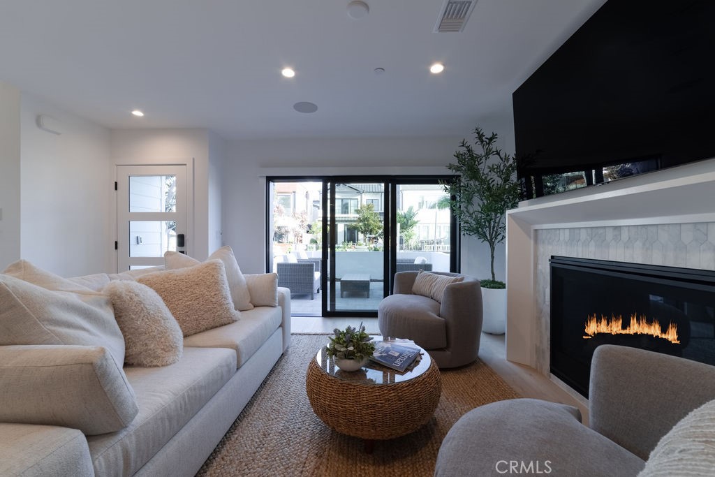 603 Acacia Avenue, Unit A Corona del Mar, CA 92625 - Photo 18 of 53 a living room with furniture a flat screen tv and a fireplace